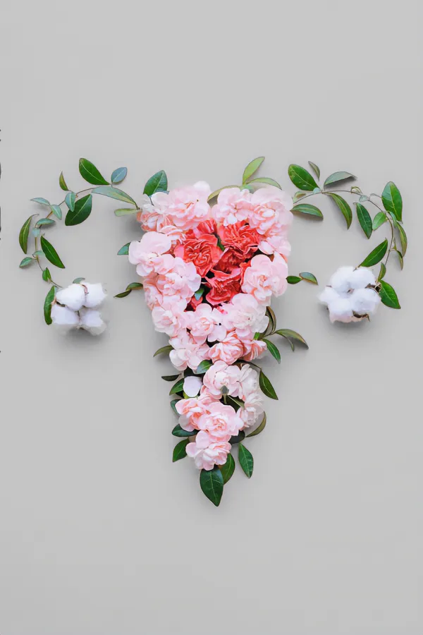 Flowers on a gray background, arranged in the shape of the female reproductive system, representing Endometriosis treatment from Deborah Wilson, M.D. & Associates in Scottsdale.
